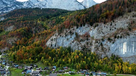 A-vibrant-mountain-village-with-colorful-houses-nestled-amidst-lush-greenery-and-snow-capped-peaks,-captured-from-an-aerial-perspective-in-clear,-sunny-weather