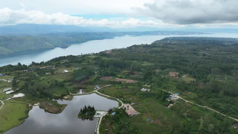 Pea-aeknetonang-lake-on-samosir-island,-surrounded-by-lush-landscapes,-aerial-view