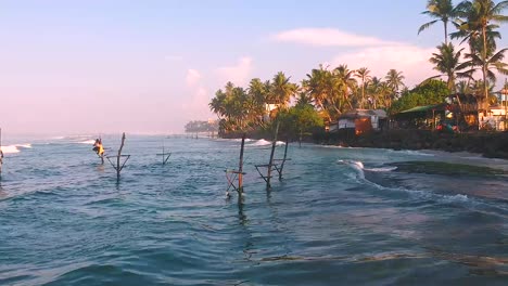 Vista-Aérea-Sobre-Las-Olas-Frente-A-Ahangama-En-Sri-Lanka-Para-Revelar-A-Un-Pescador-Sobre-Zancos