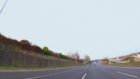 Car-POV-drives-along-M6-highway-leaving-Dublin-city-center-heading-west-below-overpass-bridges