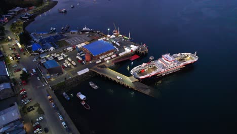 Drone-shot-of-a-car-ferry-docked-at-the-port-of-Castro,-evening-in-Chiloe,-Chile