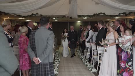 Father-of-the-bride-and-daughter-walking-down-the-wedding-venue-aisle