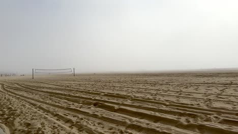 Santa-Monica-California-beach-on-a-foggy-morning---sand,-volleyball,-misty,-forward