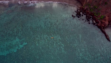 Amazing-aerial-drone-video-of-tourists-rowing-in-a-colorful-kayak-in-tropical-Hawaiian-exotic-destination-with-turquoise-calm-ocean-surface