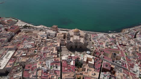 Imágenes-Aéreas-En-Círculo-De-La-Antigua-Catedral-De-Cádiz-Con-Vistas-A-La-Zona-Costera-Y-Al-Casco-Antiguo,-Cádiz,-España