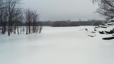 Low-altitude-flight-above-frozen-yard-with-shiny-ice-sheet-cover-on-ground