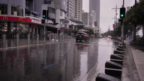 Cars-drive-along-the-Esplanade-under-heavy-rain-and-storms,-Surfers-Paradise,-South-East-Queensland