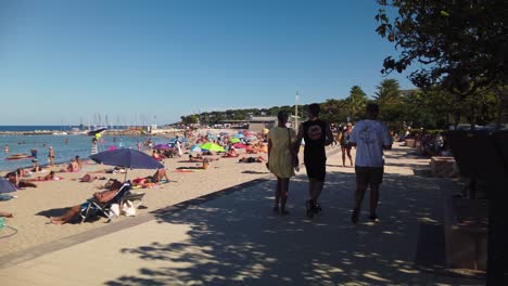 Close-view-of-people-walking-and-sunbathing-at-beach-in-Antibes