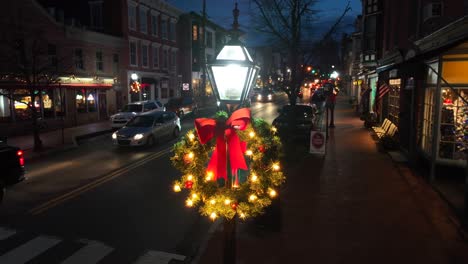 Christmas-wreath-with-lights-adorns-small-town-streetlamp-at-night