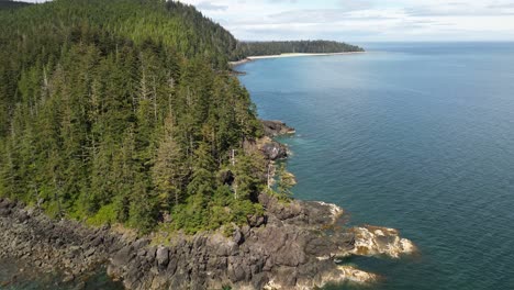 Vistas-Aéreas-Panorámicas-De-Un-Dron-Que-Se-Eleva-A-Lo-Largo-De-Una-Costa-Rocosa-Y-Alpina-Cerca-De-Un-Arenero,-Grey-Bay,-Canadá