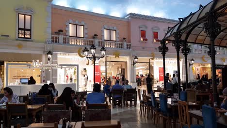 People-at-Restaurant-and-Shops-of-Villaggio-Shopping-Mall,-Doha-Qatar-Under-Artificial-Sky