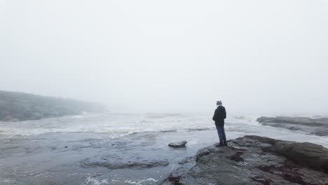 Un-Joven-Parado-Sobre-Las-Rocas-En-Un-Paisaje-Costero.