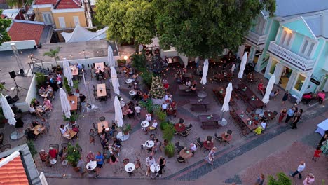 Menschen-Versammeln-Sich-Auf-Einem-Freiluftplatz-Mit-Lebhaften-Bunten-Gebäuden-Im-Dorf-Kura-Hulanda-In-Otrobanda,-Willemstad,-Curaçao