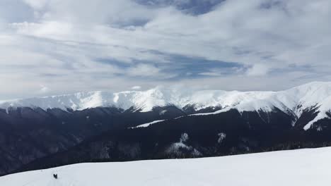 Vast-snowy-landscape-with-Iezerul-Mare-and-Batrana-Peaks,-Iezer-Papusa,-sunny-day