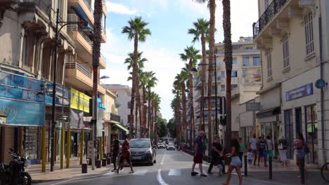 Street-traffic-on-summer-day-in-Antibes,-people-cross-road,-static