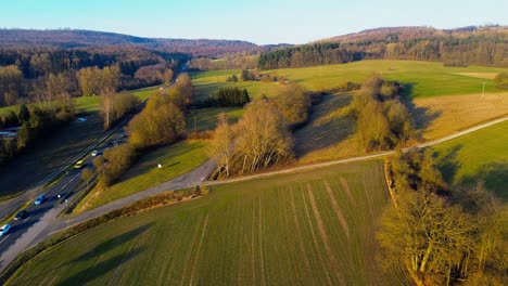 Malerische-Luftaufnahme-Einer-Landstraße,-Die-Sich-Durch-Herbstliche-Felder-Schlängelt