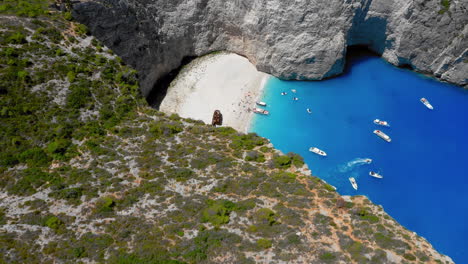 Aerial-Reveal-shot-of-Navagio-beach-in-Zakynthos-island,-Greece-during-summer