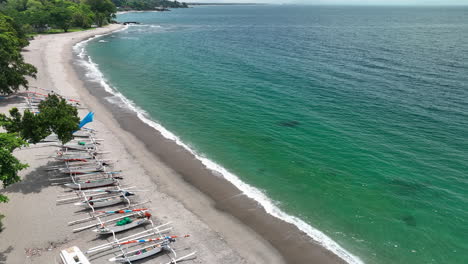 A-beached-lined-with-boats-on-the-island-of-Lombok,-Indonesia