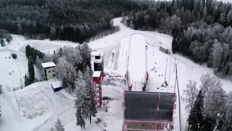 Toma-Aérea-De-Seguimiento-De-La-Torre-De-Salto-De-Esquí-De-Tehvandi-En-Otepää,-En-El-Sur-De-Estonia,-Durante-Un-Invierno-Muy-Frío-Con-Nieve.