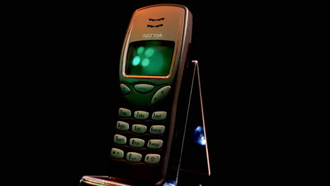 Nokia-3210-Cellular-Phone,-One-of-The-Most-Popular-GSM-Mobile-Devices,-Spinning-With-Black-Background-4k