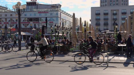 Bicicletas-Y-Peatones-Pasan-A-La-Gente-En-Un-Bar-En-Estocolmo-En-Tiempos-De-Corona