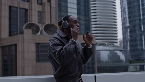 Young-and-ambitious-black-man-in-a-big-city,-parallax-shot-with-skyscrapers-in-background