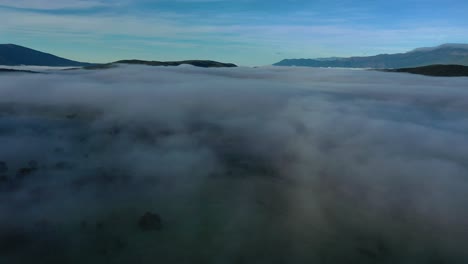 Vuelo-De-Drones-Sobre-Un-Mar-De-Nubes-En-Un-Valle-Al-Amanecer-Realizando-Un-Giro-De-Cámara-A-La-Derecha-Con-Un-Cielo-Azul-Con-Nubes-Altas-En-Invierno-En-ávila-España