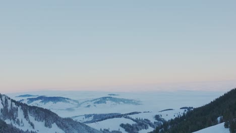 Erleben-Sie-Die-Atemberaubende-Schönheit-Des-Sonnenaufgangs-über-Einer-Schneebedeckten-Bergsilhouette-Durch-Diese-Faszinierende-Drohnenaufnahme