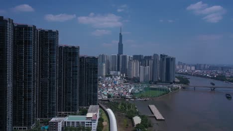 La-Ciudad-De-Ho-Chi-Minh,-El-Río-Saigón-Y-El-Horizonte-De-Binh-Thanh-En-Un-Día-Soleado-Y-Despejado-Con-Un-Edificio-Emblemático-Desde-Una-Grúa-Con-Drones