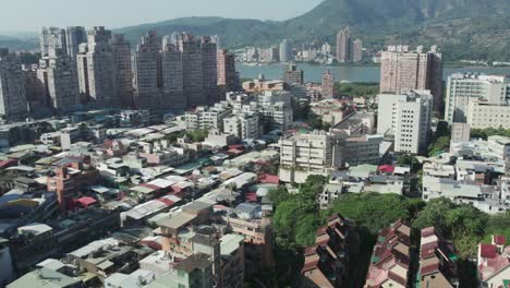 Drone-View-of-City-Buildings-Along-Zhuwei's-Skyline-in-Tamsui-district,-Taipei