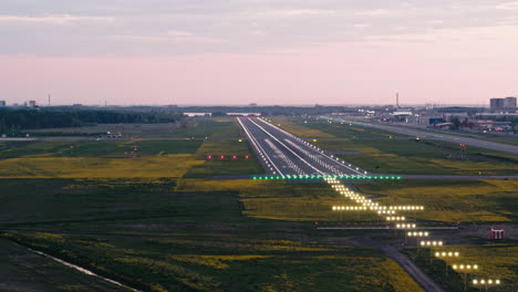 Volando-Alrededor-De-La-Zona-De-Aterrizaje-De-La-Pista-Del-Aeropuerto-De-Tallin-Al-Atardecer-Con-Las-Luces-De-Aproximación-Encendidas-Y-Los-Destellos-Rodantes