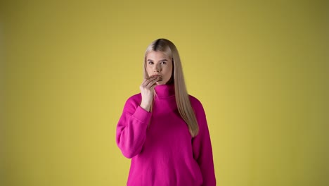 Cute-European-woman-eating-a-chocolate-waffle-in-yellow-studio-background