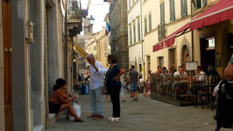 People-in-a-public-narrow-stone-street-in-Monte-San-Savino,-Italy