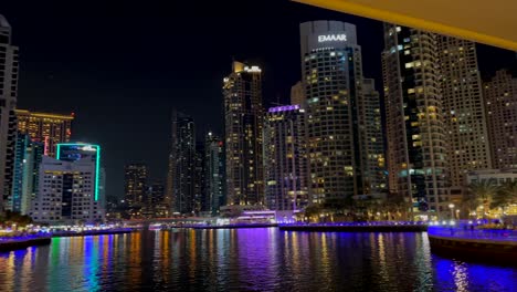 Toma-Panorámica-De-La-Vista-Nocturna-De-Los-Rascacielos-En-El-Puerto-Deportivo-De-Dubai:-Un-Barrio-Residencial-Y-Un-Distrito-En-Dubai.