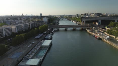 Puente-Pont-De-Bercy-Con-La-Piscina-Josephine-Baker-En-Primer-Plano-Y-El-Nuevo-Palacio-Del-Ministerio-De-Economía-Y-Finanzas-En-La-Otra-Orilla,-París-En-Francia