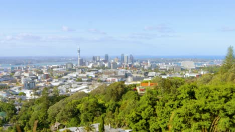 Una-Toma-Itinerante-Del-Horizonte-De-Auckland-En-Nueva-Zelanda-Vista-Desde-La-Distancia-Con-Abundante-Vegetación-A-La-Vista-En-Una-Tarde-Soleada-Y-Despejada-Con-Un-Cielo-Azul