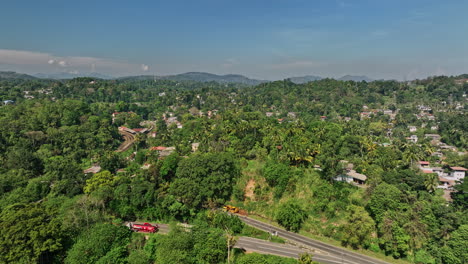Peradeniya-Sri-Lanka-Aerial-v2-establishing-shot-drone-flyover-Mahaweli-river-along-A1-main-road-capturing-townscape,-railway-station-and-hillside-landscape-view---Shot-with-Mavic-3-Cine---April-2023