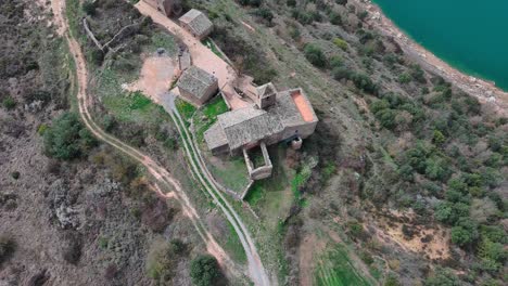 Aerial-descending-view-of-Rialb-tower-and-river,-Lleida-in-Spain