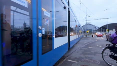 The-side-view-of-a-tram-in-Amsterdam-captures-the-city's-modern-public-transportation-against-an-architectural-backdrop