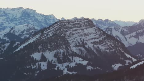 Mit-Einer-Drohne-Aufgenommenes-Filmmaterial-Bietet-Einen-Majestätischen-Blick-Auf-Den-Sonnenaufgang-über-Einer-Schneebedeckten-Bergsilhouette