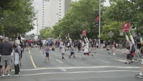 Hoopfest-2018---crowd-walks-by-as-kids-practice-basketball