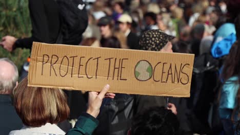 "Protect-the-oceans"-sign-at-climate-protest-rally-in-Stockholm,-slo-mo