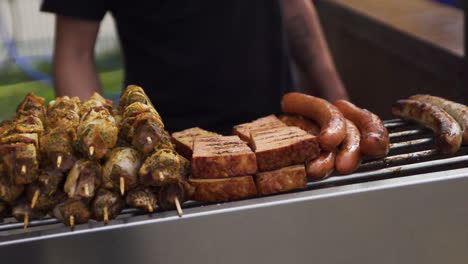 Chef-using-kitchen-tong-to-put-pieces-of-meat-on-elevated-section-to-keep-warm