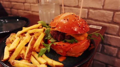 Burger-with-fresh-tomato,-lettuce-and-pickles-served-with-french-fries