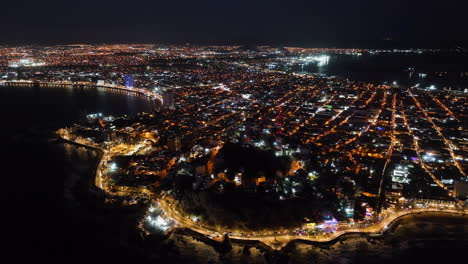 Panoramic-drone-shot-overlooking-the-illuminated-coastline-of-Mazatlan,-Mexico