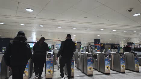 Busy-London-Oxford-Street-station-with-commuters-passing-through-ticket-barriers,-blurred-motion