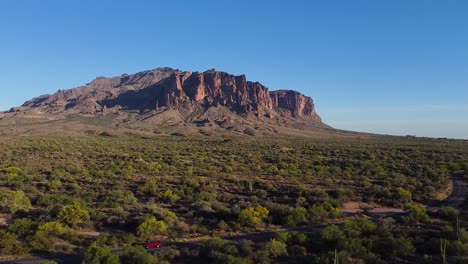 Pickup-truck-driving-on-desert-road-leading-to-Superstition-Mountains-in-Sonoran-Desert