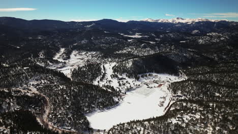 Unique-high-altitude-incredible-scenic-view-of-Evergreen-Colorado-aerial-drone-Mount-Evans-Bluesky-three-sisters-lake-house-golf-course-high-school-winter-sunny-morning-Denver-open-space-backward