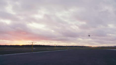 Bombardier-CRJ-900-airliner-landing-at-Tallinn-airport-on-summer-sunset-with-red-clouds