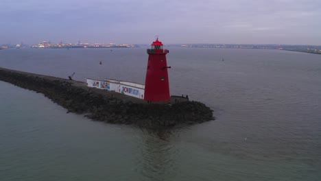 Drohnenumlaufbahn-Um-Den-Roten-Poolbeg-Leuchtturm-Mit-Blick-Auf-Die-Lichter-Der-Stadt-Dublin-In-Der-Ferne